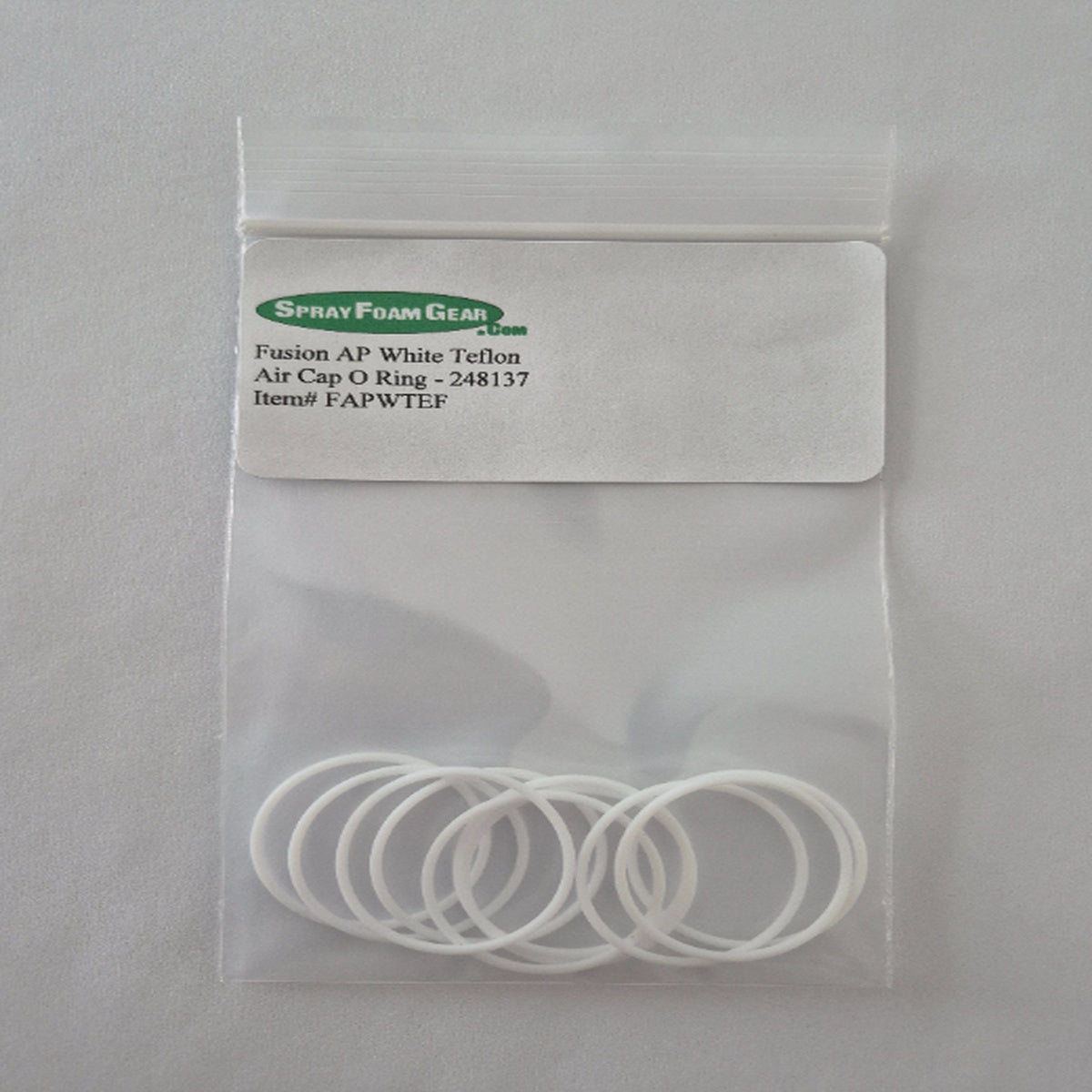 Clear plastic bag with white o-rings and a label on a gray background