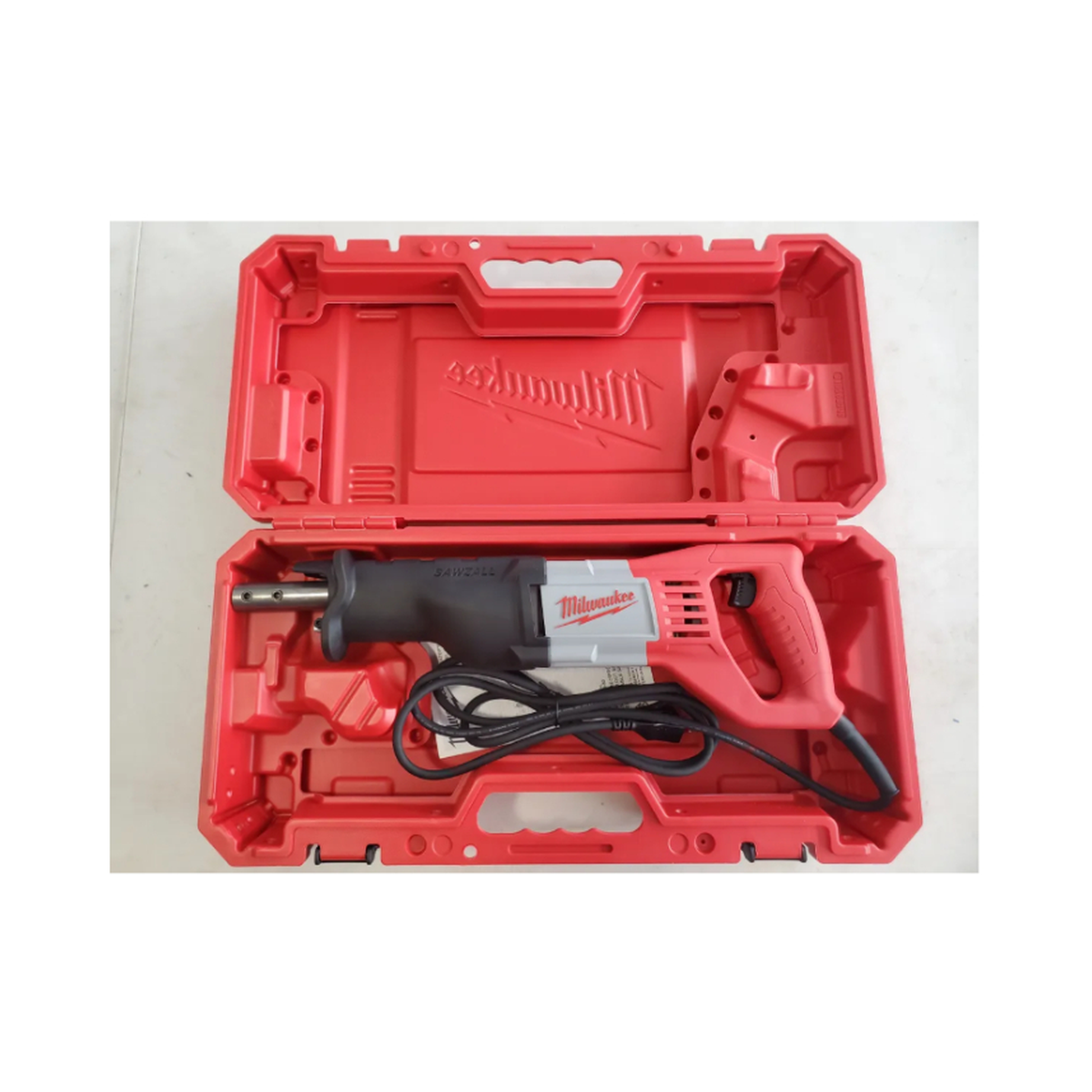 Red Milwaukee reciprocating saw tool in an open red case on a white background
